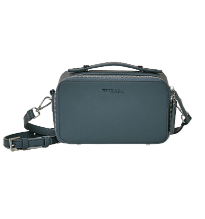 Teal blue coloured crossbody bag with silver hardware sits against a white background.