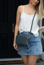 Load image into Gallery viewer, Lady wearing a short denim skirt and white singlet wears a teal blue vegan leather crossbody bag.
