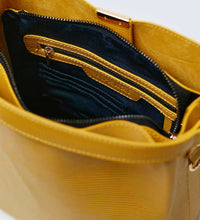 Load image into Gallery viewer, The inside of a mustard yellow vegan leather shoulder bag showing blue recycled plastic lining with a gold internal zip and gold hardware.
