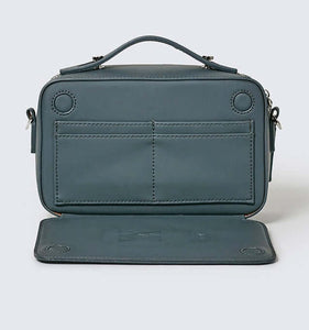 Teal vegan leather crossbody bag showing a hidden card compartment set against a white background.